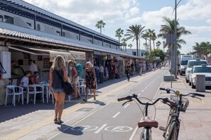A street with outdoor seating, palm trees, and a bicycle in the foreground. - Casa Tiago With High-speed Wifi and Smart-tvv (La Oliva)