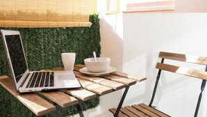 A laptop on a wooden table with a bowl and cup beside it, a chair, and a green wall with a window in the background. - Casa Tiago With High-speed Wifi and Smart-tvv (La Oliva)