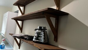 Esquina de una habitación con una pared blanca y una estantería de madera.