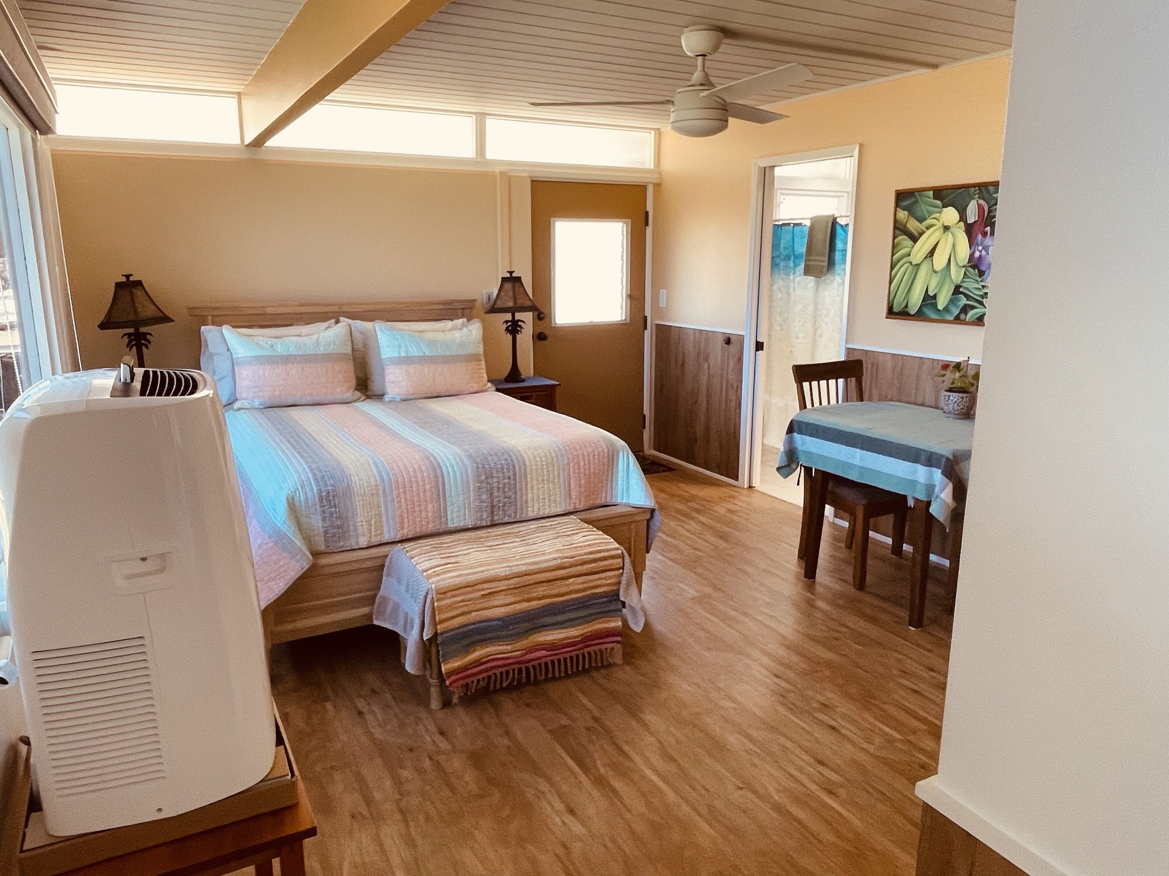 A bedroom with a bed, bedside tables, a desk, and a chair.