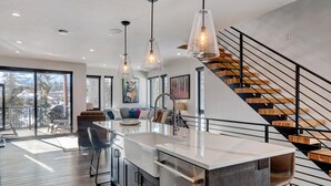 A modern kitchen with a central island, stainless steel appliances, and pendant lighting.