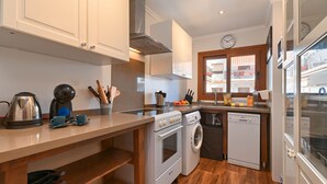 A modern kitchen with white cabinets, a stainless steel kettle, a coffee maker, and a dishwasher. - Adumar - Javea, Costa Blanca (Javea)
