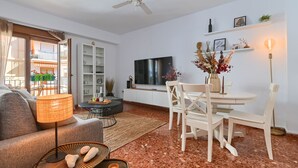 A modern living room with a sofa, a dining table with chairs, a TV, and a ceiling fan. - Adumar - Javea, Costa Blanca (Javea)