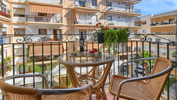 A balcony with wicker chairs, a glass table, and a potted plant. - Adumar - Javea, Costa Blanca (Javea)