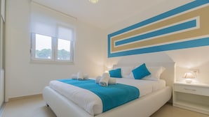 A modern bedroom with a large bed, a nightstand, a window, and a wall with geometric design. - Makarska Lux Apartments A4 (2+1) (Veliko Brdo, Makarska)