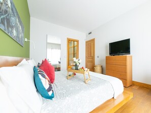 A bedroom with a bed, a wooden dresser, a television, and a window. - Private Pool in Playa Blanca (Playa Blanca)