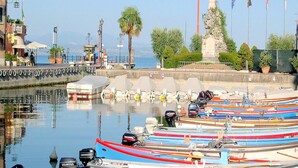 Un port de plaisance avec des bateaux amarrés, un monument et un ciel dégagé.