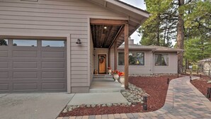 Et moderne hus med en overdækket veranda, garage og en anlagt forhave.