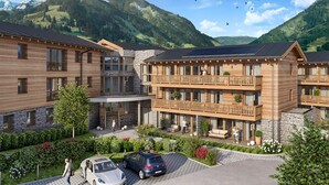 Un hôtel au design moderne, doté d’une cour intérieure avec un abri pour voitures, entouré d’une végétation luxuriante et offrant une vue sur les montagnes.