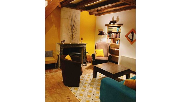 Een gezellige woonkamer met een open haard, een boekenkast en een comfortabele zithoek.