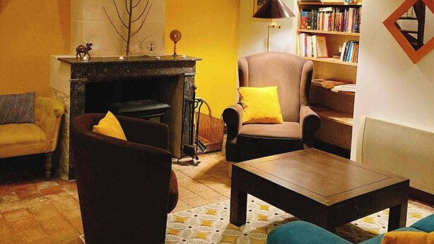 Un saló acollidor amb una llar de foc, una biblioteca i una zona de seients confortable.