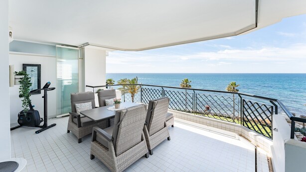 Un balcone con vista sul mare, arredi in vimini e un tapis roulant.