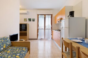 A compact living space with a kitchenette, a dining area, and a small seating area.
