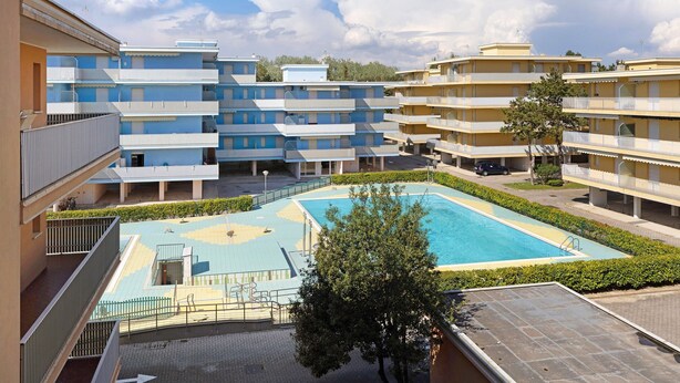A multi-story residential building with a swimming pool and balconies. - Studio "Valbella A" in Residence with 12 Pools (Bibione)