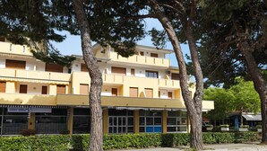 A multi-story building with a yellow facade, large windows, and a visible entrance. - Apartment "Condominio Simma 1B6" with A/C & Terrace (Bibione)