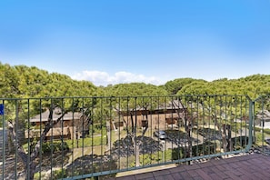 A residential area with houses, a green fence, and trees.