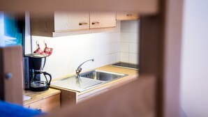 A kitchen with a coffee maker, a sink, and wooden cabinets. - Apartment 'Issingerhof 1' with Mountain Views, Garden & Wi-Fi (Campo di Tures)