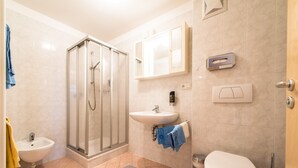 A bathroom with a shower, sink, toilet, and a towel rack. - Apartment 'Issingerhof 1' with Mountain Views, Garden & Wi-Fi (Campo di Tures)