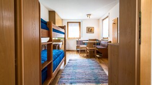 Un dormitorio con literas, un escritorio, una silla y una ventana.