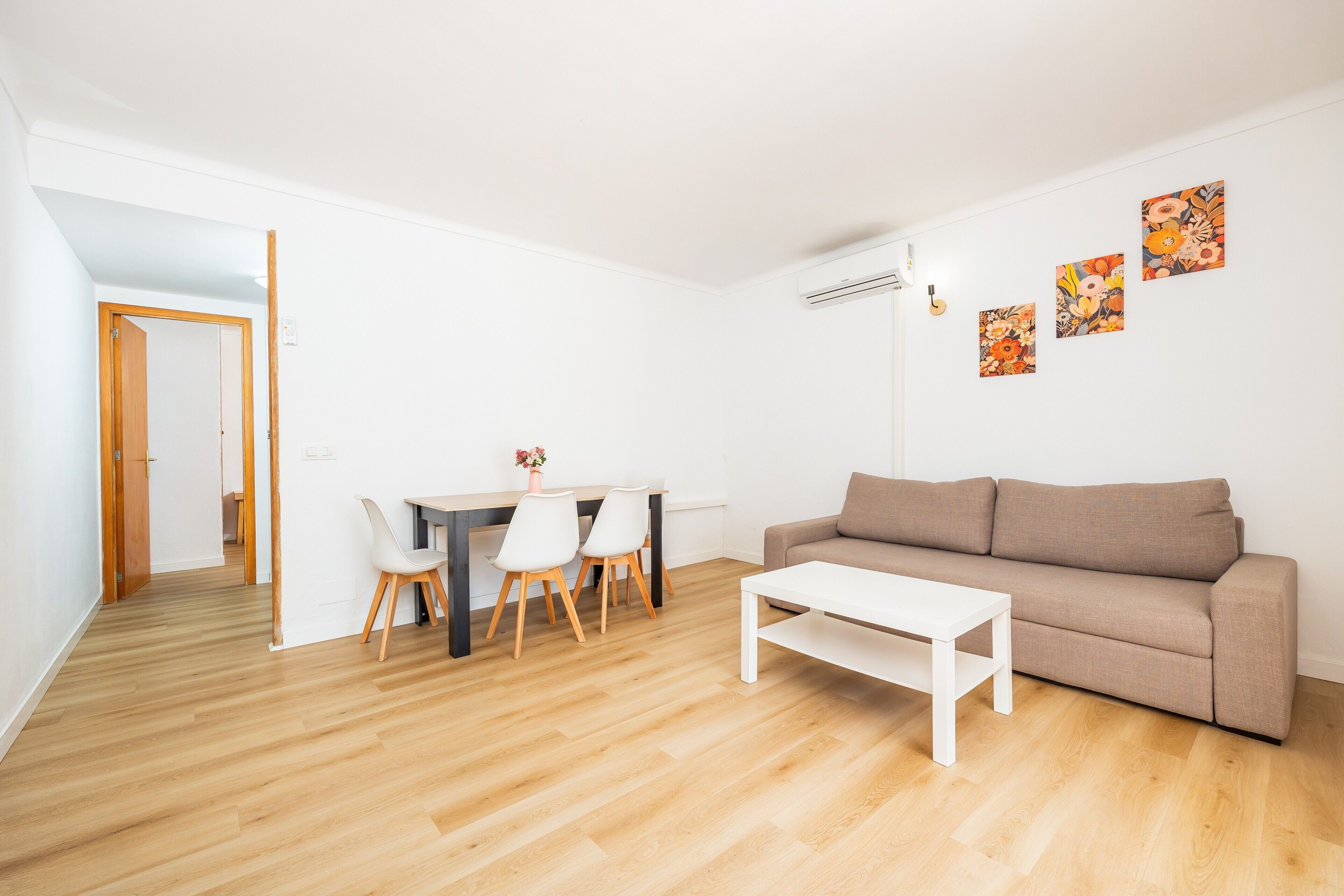 Ein modernes Wohnzimmer mit einer Couch, einem Couchtisch und einem Essbereich mit Stühlen und einem Tisch.