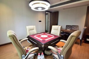 Un salón de conferencias con una mesa redonda, cuatro sillas y una araña.