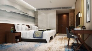 Ein modernes Hotelzimmer mit einem großen Bett, einem Schreibtisch und einem am Wand befestigten Fernseher.