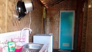 A compact kitchen with a stove, sink, and a small refrigerator.