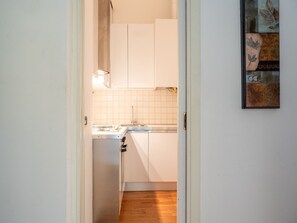 Deluxe appartement | Privékeuken | Een koelkast/vriezer, een vaatwasser, kookgerei, borden en bestek
