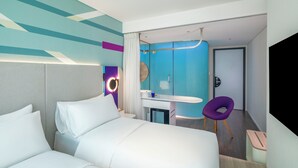 A modern hotel room with a bed, a desk with a chair, a bathroom, and a TV. - Tru by Hilton Viet Tri City Centre (Thanh Mieu)