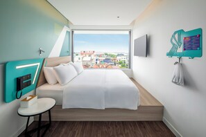 A modern hotel room with a large bed, a small table, a mounted TV, and a city view. - Tru by Hilton Viet Tri City Centre (Thanh Mieu)