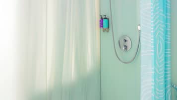 A bathroom with a shower, a bathtub, and a curtain.
