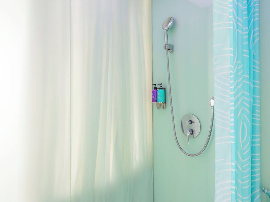 Ein Badezimmer mit Dusche, Badewanne und Vorhang.