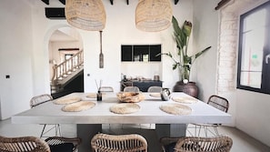 Enjoy meals in this inviting dining area with a table for six, surrounded by comfortable chairs and natural lighting.