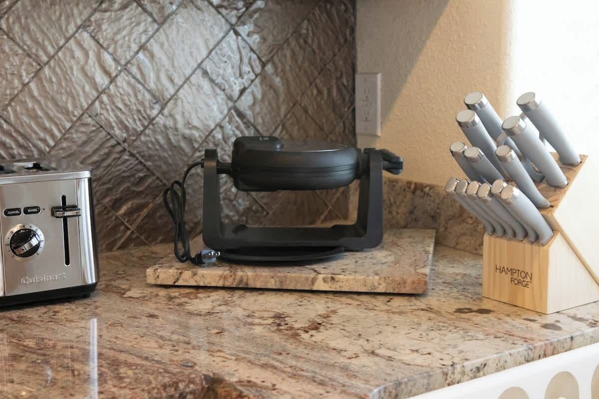 A kitchen counter with a toaster, a portable electric kettle, and a knife block.