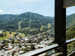 Une ville où se dresse une église imposante, entourée de collines et de verdure.