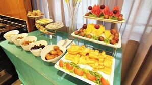 Ein reichhaltiges Buffet mit verschiedenen Speisen, darunter Obst, Nüsse und Gebäck.