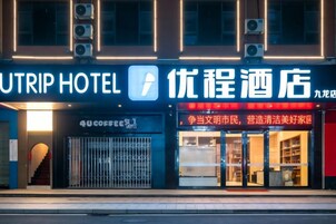 Un hotel con un letrero llamativo, una cafetería y una tienda con caracteres chinos.