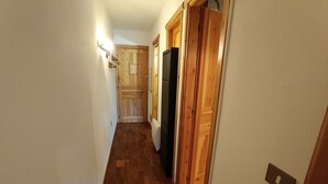 A narrow hallway with wooden flooring and doors leading to different rooms. - Studio for 4 with terrace, garden and parking (Montgenèvre)