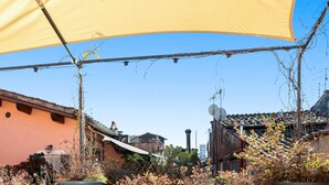 Une cour avec un auvent jaune, des bâtiments rustiques et un cactus.