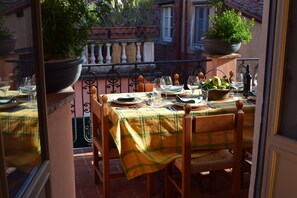 A dining table set for four with a checkered tablecloth, surrounded by wooden chairs.
