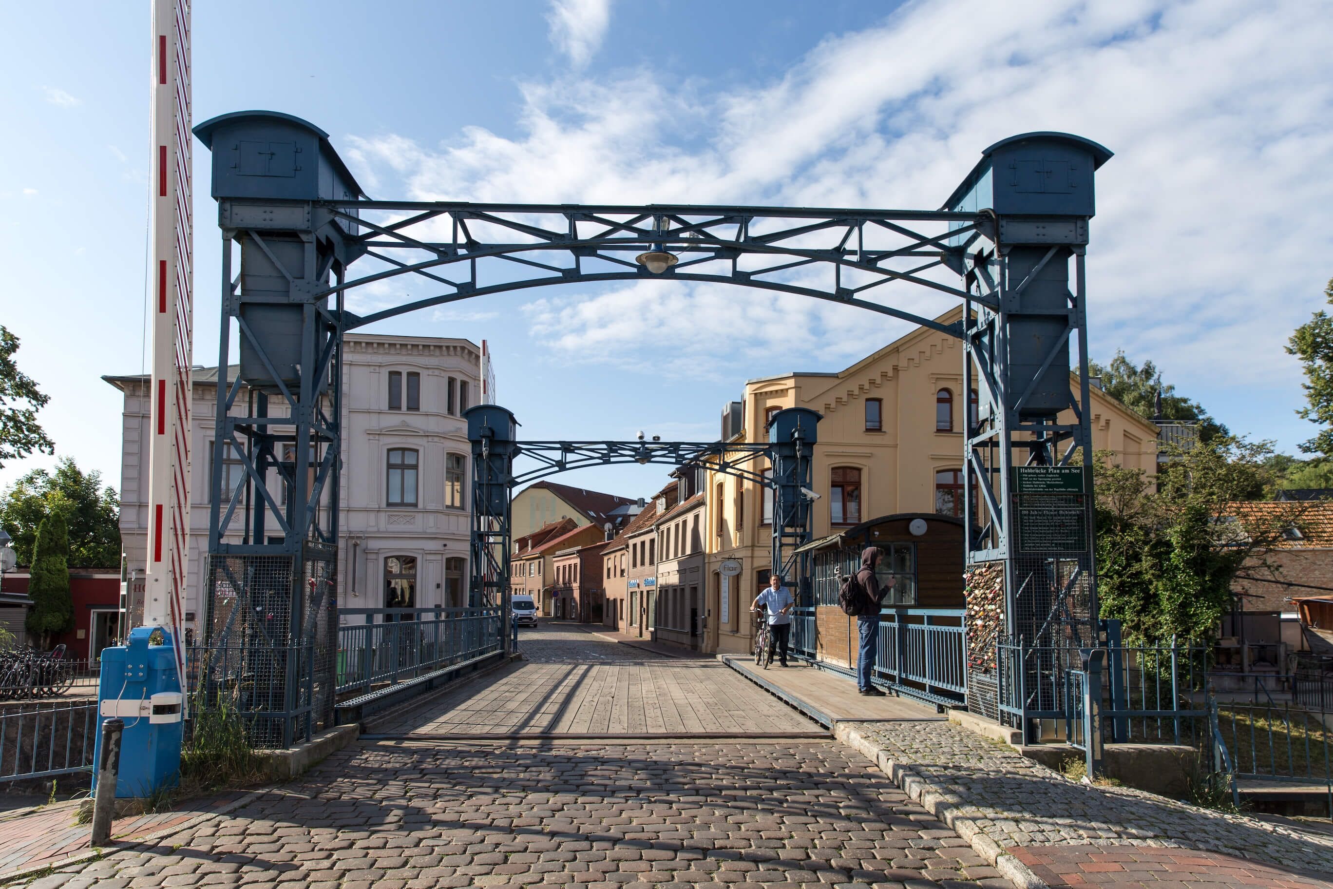 A stone bridge with metal railings and a metal archway.