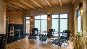 Una habitación amplia con pisos de madera, ventanas grandes y una chimenea.