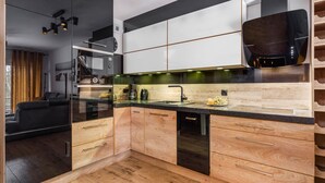 Una cucina moderna con mobili in legno, un piano di lavoro nero e un forno integrato.