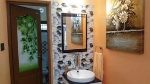 A bathroom with a white sink, a mirror, and a towel rack.