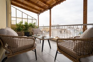 A covered balcony with wicker furniture, a glass table, and potted plants. - The Athens Gathering - Hip area (Athens)