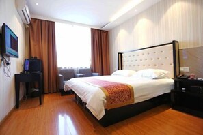 A hotel room with a large bed, a desk with a computer, a TV, and a window with curtains. - Baishang Hotel‌ (Wenzhou)
