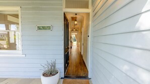 A hallway with a wooden floor, a potted plant, and a sign reading "Blue Belle."