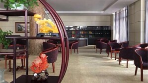 Eine moderne Hotelhalle mit einer Rezeption, Bücherregalen und einer Sitzecke.