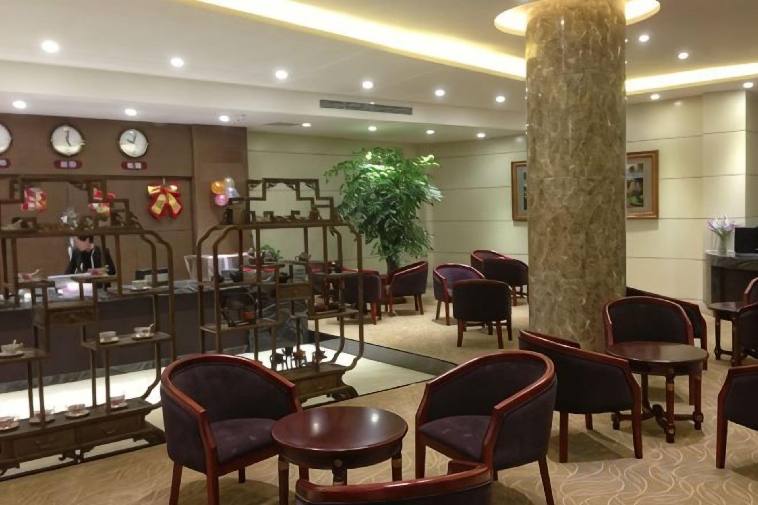 A lobby with a reception desk, seating area, and a large pillar.