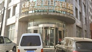 A hotel entrance with a curved facade and a sign in a foreign language. - Jinqiao Holiday Business Hotel (Wafangdian)